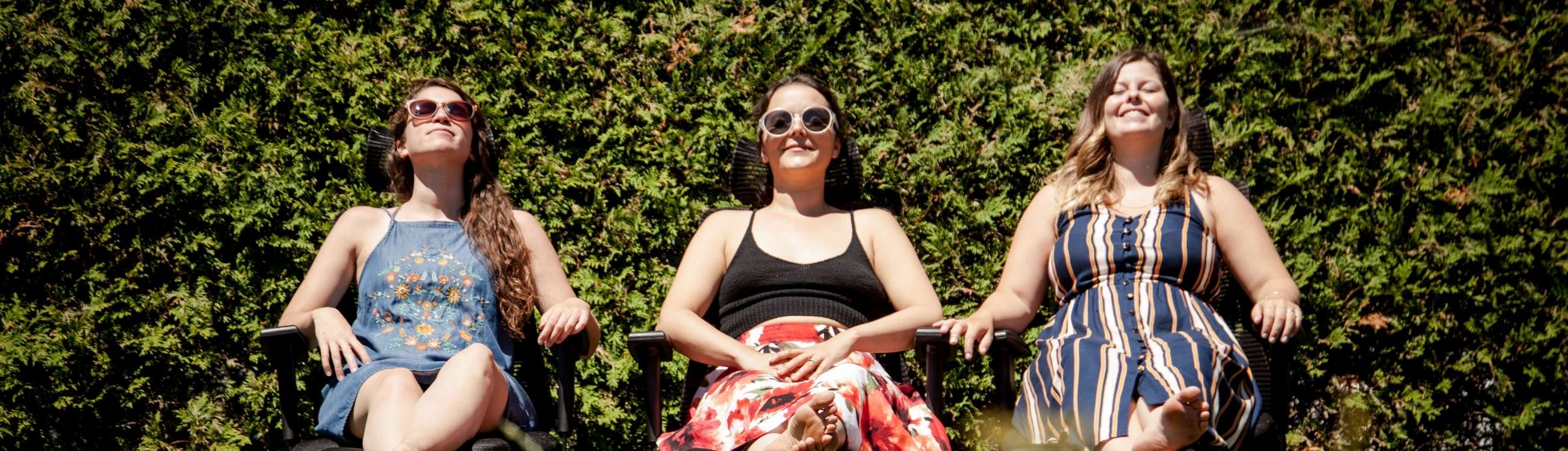 Trois femmes sont assises sur des chaises et se font griller au soleil. 