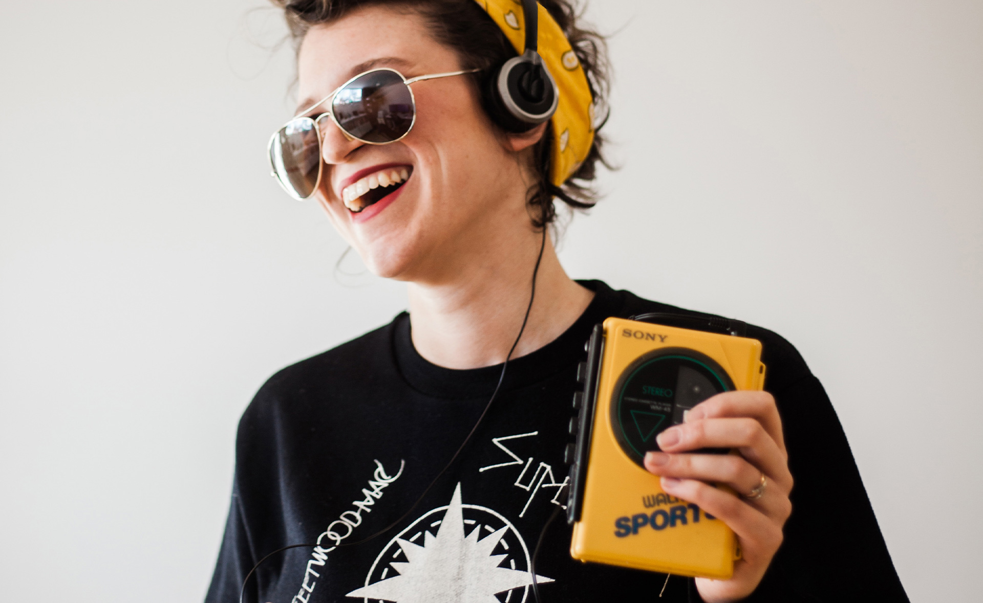 Une femme souriante écoutant de la musique dans un walkman