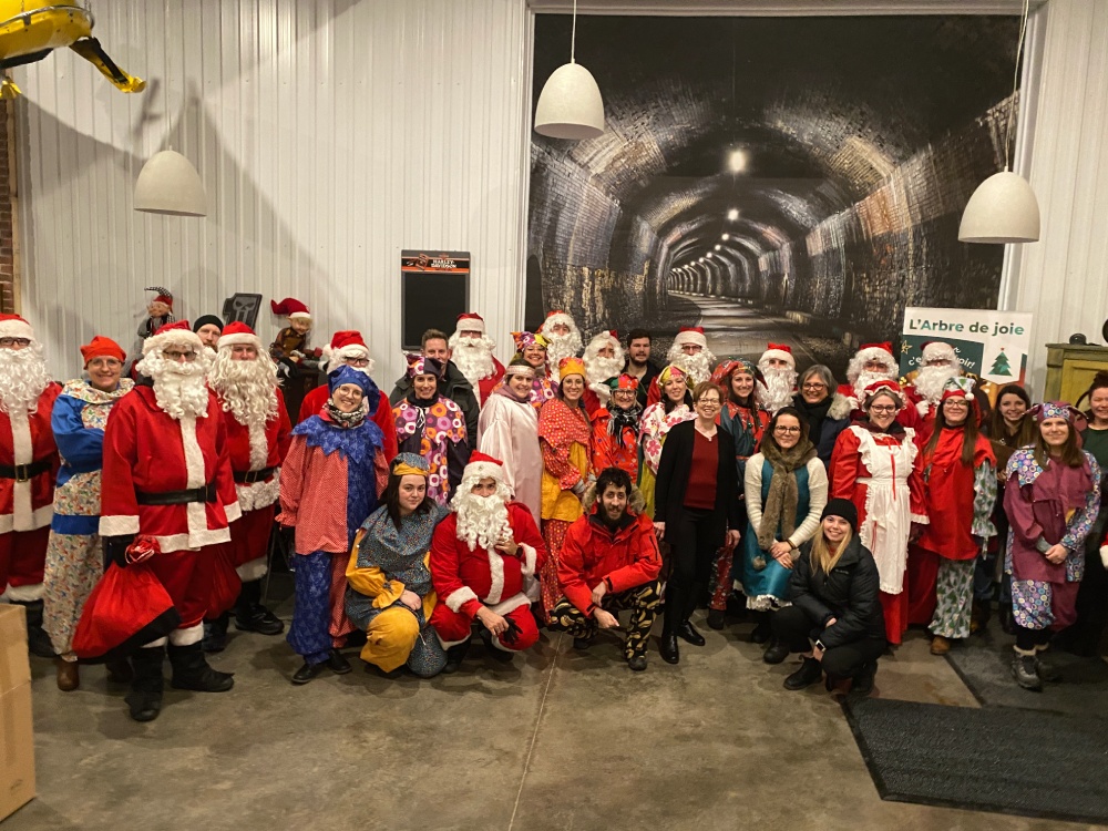 Groupe de personnes déguisés en Père Noël ou Mère Noël qui se prépare à distribuer des cadeaux de Noël pour les enfants défavorisés